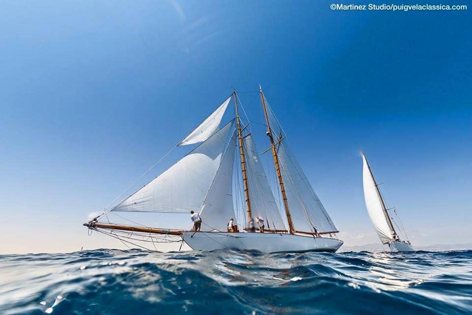 Beautiful sail boat all in the wind while at sea.